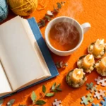 Bright flat-lay of cozy hobby objects: knitting yarn, a book, tea cup, candles and a jigsaw puzzle in warm saturated colours.
